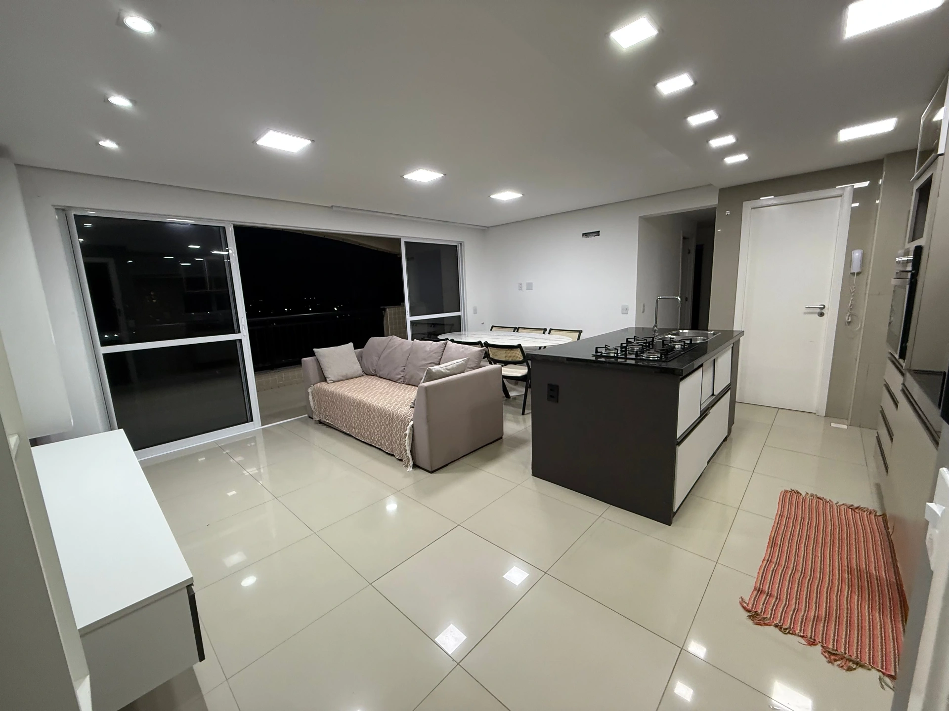 Sala integrada com cozinha e varanda ao fundo
