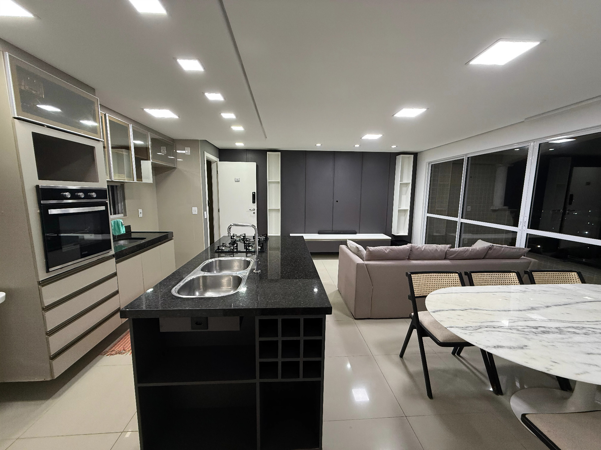 Cozinha com ilha de granito e sala ampla